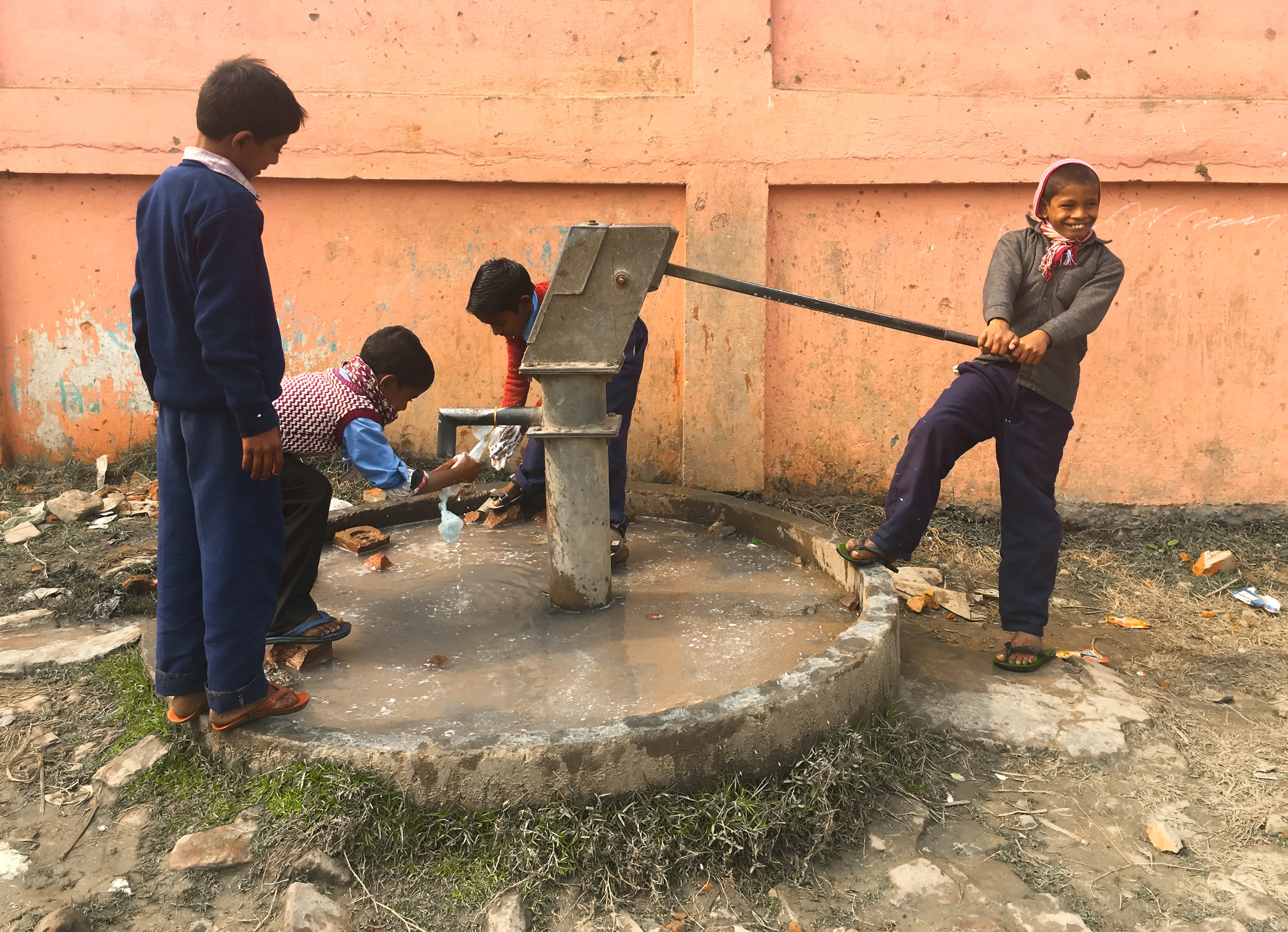 Children at a village water pump, the kind of community Neeyah's portfolio work reaches